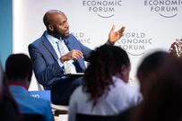 Larry Madowo moderating a panel discussion at the Word Economic Forum stage in January 2022