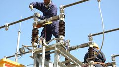 A Kenya Power employee working on a power line