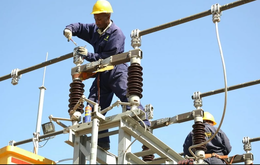 A Kenya Power employee working on a power line