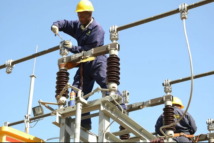 A Kenya Power employee working on a power line