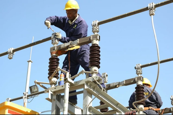 A Kenya Power employee working on a power line