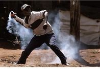 A protestor throws a tear gas