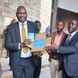 Immigration and Citizen Services PS Julius Bitok holding passports