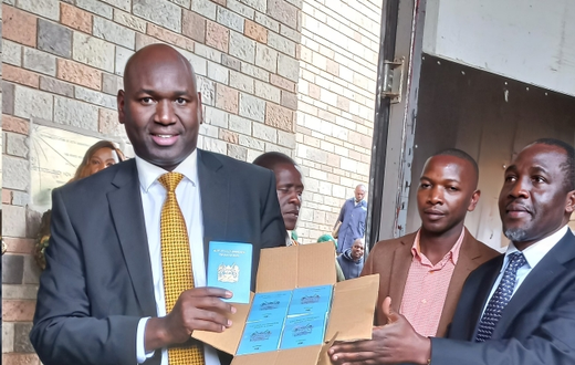 Immigration and Citizen Services PS Julius Bitok holding passports