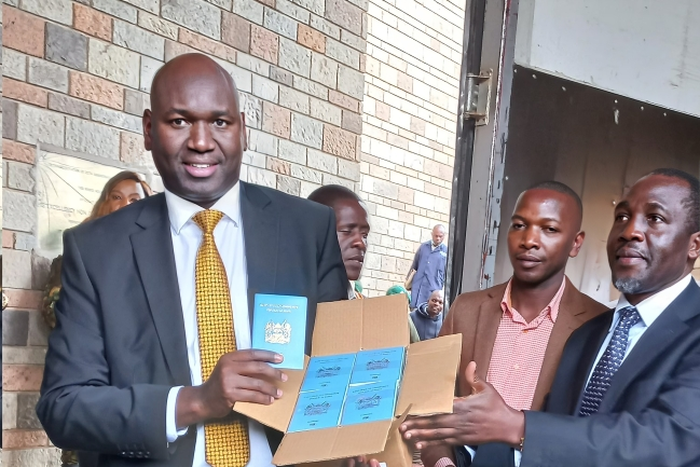 Immigration and Citizen Services PS Julius Bitok holding passports