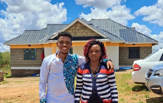 Sammy Kioko and his mother in their newly constructed house