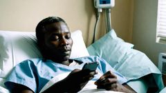 AI generated image of a patient-in-a-hospital-bed-holding-a-phone