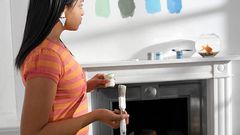 Young woman holding paint and brush