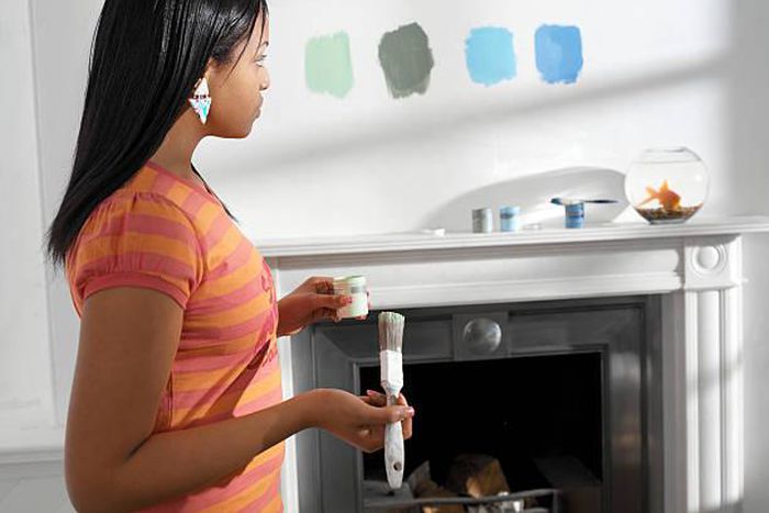 Young woman holding paint and brush