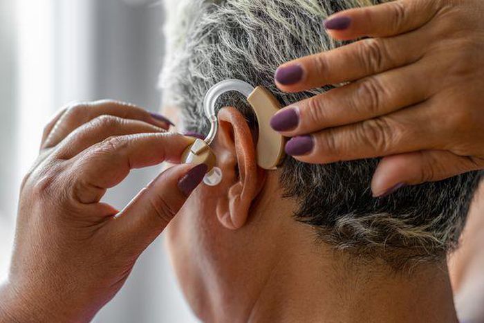 An elderly woman wearing hearing aid