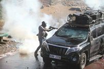 Police officer capture firing teargas at close range into vehicle during protests in Nairobi on March 30, 2023