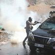 Police officer capture firing teargas at close range into vehicle during protests in Nairobi on March 30, 2023