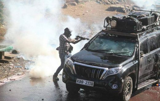 Police officer capture firing teargas at close range into vehicle during protests in Nairobi on March 30, 2023