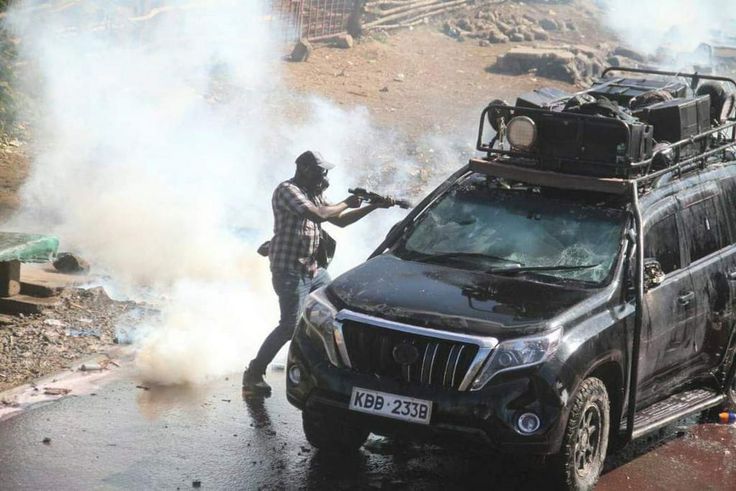 Police officer capture firing teargas at close range into vehicle during protests in Nairobi on March 30, 2023