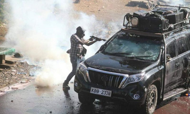 Police officer capture firing teargas at close range into vehicle during protests in Nairobi on March 30, 2023