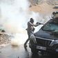 Police officer capture firing teargas at close range into vehicle during protests in Nairobi on March 30, 2023