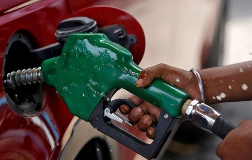 FILE PHOTO: A worker holds a nozzle to pump petrol into a vehicle at a fuel station in Mumbai, India, May 21, 2018. REUTERS/Francis Mascarenhas/File Photo