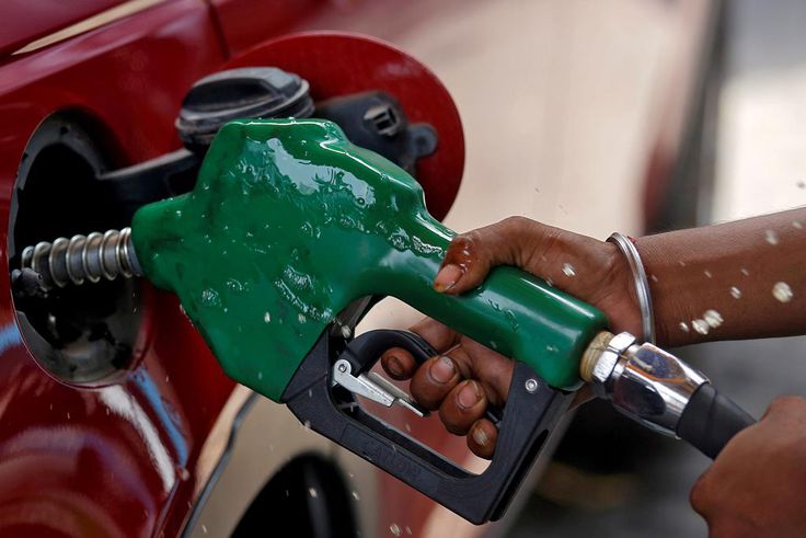 FILE PHOTO: A worker holds a nozzle to pump petrol into a vehicle at a fuel station in Mumbai, India, May 21, 2018. REUTERS/Francis Mascarenhas/File Photo