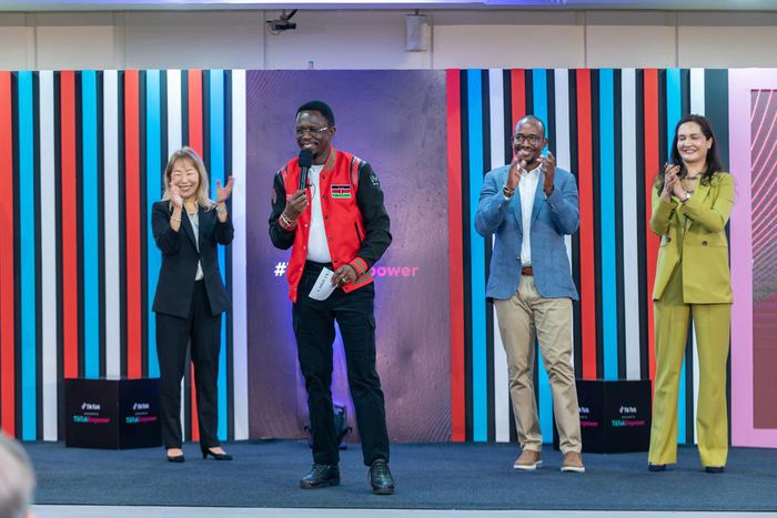 Cabinet Secretary Ministry of Youth Affairs, Creative Economy, and Sports Ababu Namwamba, EGH (centre) addresses the crowd at the launch of #TikTokEmpower with Yunus Social Business. Flanking him is Ara Yoo Han, Global Social Impact Lead at ByteDance /...