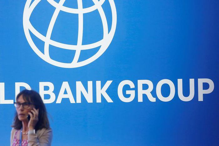 FILE PHOTO: A participant stands near a logo of World Bank at the International Monetary Fund - World Bank Annual Meeting 2018 in Nusa DuaReuters