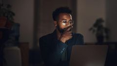 Shot of a young businessman using a laptop during a late night at work
