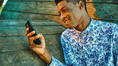 A young man scrolling through his phone