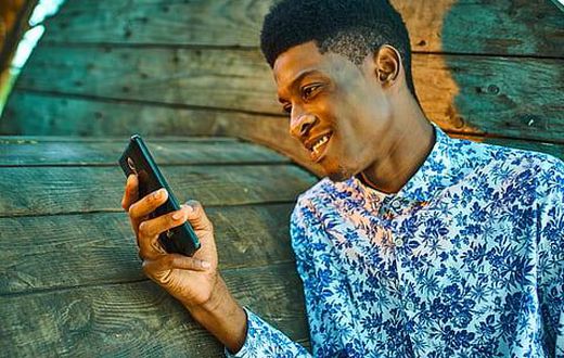 A young man scrolling through his phone