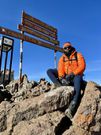 Larry Madowo takes a photo on the third highest peak at Mt Kenya