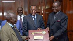 Former President Uhuru Kenyatta and former Nairobi Governor Evans Kidero present the ‘Key to the City’ to pioneer businessman Mzee Gerald Gikonyo at State House in Nairobi, April 15, 2017.
