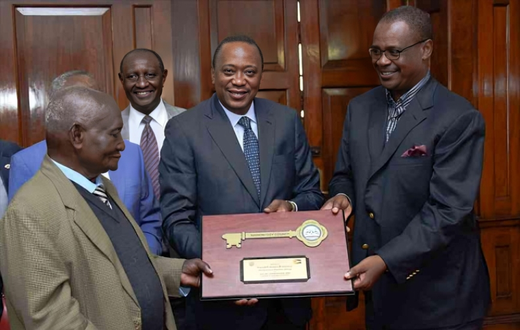 Former President Uhuru Kenyatta and former Nairobi Governor Evans Kidero present the ‘Key to the City’ to pioneer businessman Mzee Gerald Gikonyo at State House in Nairobi, April 15, 2017.