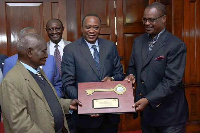Former President Uhuru Kenyatta and former Nairobi Governor Evans Kidero present the ‘Key to the City’ to pioneer businessman Mzee Gerald Gikonyo at State House in Nairobi, April 15, 2017.