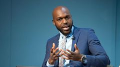 Larry Madowo moderating a panel discussion at the Word Economic Forum stage in January 2022