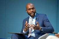 Larry Madowo moderating a panel discussion at the Word Economic Forum stage in January 2022