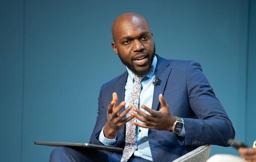 Larry Madowo moderating a panel discussion at the Word Economic Forum stage in January 2022