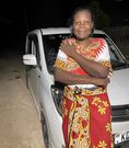 Vincent Mboya's mothe posing next to the YouTuber's first car