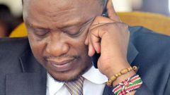 President Uhuru Kenyatta using a mobile phone