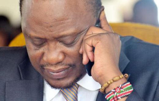 President Uhuru Kenyatta using a mobile phone