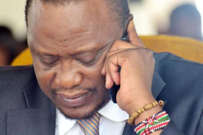 President Uhuru Kenyatta using a mobile phone