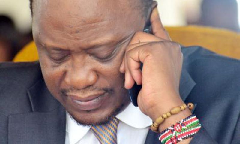 President Uhuru Kenyatta using a mobile phone