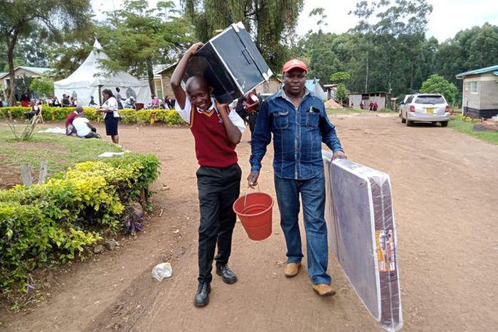 A form one student arrives at Kerugoya Boys Secondary School in Kirinyaga county accompanied by his parent. Photo credit: George Munene | Nation Media Group