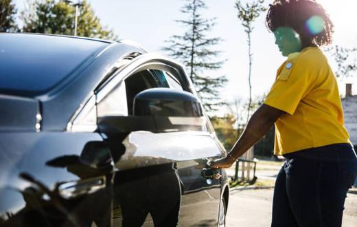 Young woman opening the car door. Credit: Fotostorm
