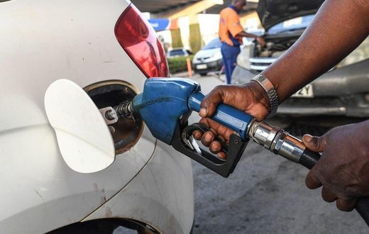 A pump attendant fills a car with fuel at the OLA petrol station