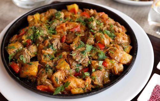 Beef stew garnished with cilantro [Image Credit: Valeria Boltneva]