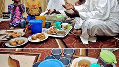 A father and his family sit around a meal for Iftar during Ramathan