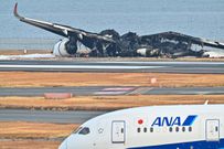 An All Nippon Airlines (ANA) plane taxis past the burnt wreckage of a Japan Airlines (JAL) passenger plane at Tokyo International Airport on January 3, 2024.Richard A. Brooks/AFP/Getty Images
