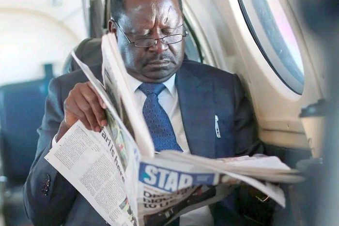 Raila Odinga reading a newspaper [Photo: Hon Didmus Barasa/Twitter]
