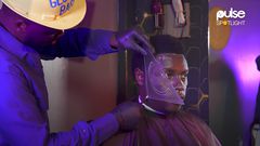 Zachariah Mwaura shaving a client with geometric tools