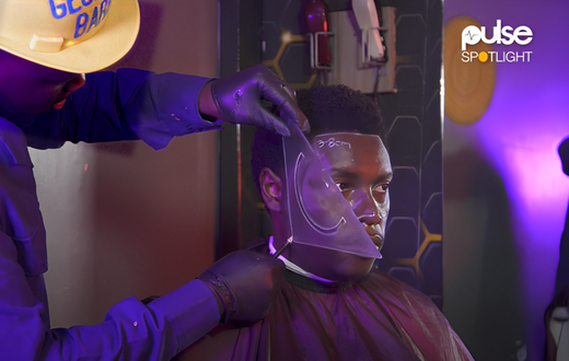 Zachariah Mwaura shaving a client with geometric tools