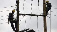 [FILE] Kenya Power and Lighting Company (KPLC) live line experts dismantle power cables to relocate power lines to pave way for the construction of the Nairobi Expressway in Westlands, Nairobi, on September 24, 2020. (Photo by SIMON MAINA/AFP via Getty...
