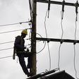 [FILE] Kenya Power and Lighting Company (KPLC) live line experts dismantle power cables to relocate power lines to pave way for the construction of the Nairobi Expressway in Westlands, Nairobi, on September 24, 2020. (Photo by SIMON MAINA/AFP via Getty...